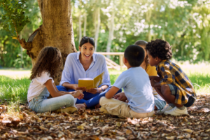 Teacher Reading to kids in forest